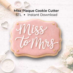 Puede incluir: Una galleta rosa en forma de placa con las palabras "Miss to Mrs" en escritura blanca. La galleta tiene un borde marrón claro y está decorada con chispas doradas. La imagen también incluye el texto "Miss Plaque Cookie Cutter STL Instant Download".