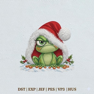 May include: An embroidered green frog with a grumpy expression wearing a red Santa hat with white fur trim. The frog sits on a patch of white snow with small green holly leaves and red berries. Text at the bottom reads: DST | EXP | JEF | PES | VP3 | HUS