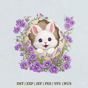 May include: An embroidered design featuring a white bunny emerging from a cracked egg, surrounded by purple flowers. The bunny has pink-lined ears and a smiling face. The design is set against a light blue background, evoking a springtime theme.