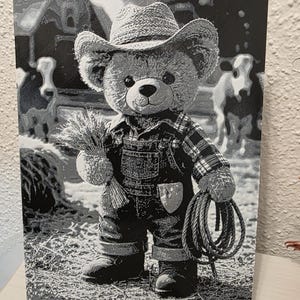 May include: Black and white print of a teddy bear dressed as a farmer, wearing a straw cowboy hat, plaid shirt, and denim overalls. The bear holds a bundle of wheat and a rope, with a farm scene background.