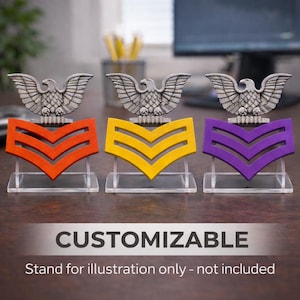 Peut inclure: Trois insignes de grade militaire orange, jaune et violet, chacune surmontée d'un emblème d'aigle argenté. Les chevrons sont présentés sur des socles en acrylique transparents. Le mot "CUSTOMIZABLE" est en bas.