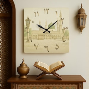 May include: Square wall clock with a beige face featuring a mosque illustration and Arabic numerals. Black clock hands indicate the time. The clock hangs above a wooden table with a decorative vase and an open book on a wooden stand.