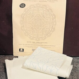May include: A pre-printed wholecloth quilt top kit by Benartex featuring a circular holiday design with holly leaves and berries. The package includes 100% cotton muslin fabric with a pre-stenciled washout pattern, matching binding, and instructions.