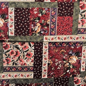 May include: A patchwork fabric featuring a floral pattern in shades of red, green, brown, and cream. The fabric incorporates a variety of floral designs, including roses, daisies, and other small flowers.