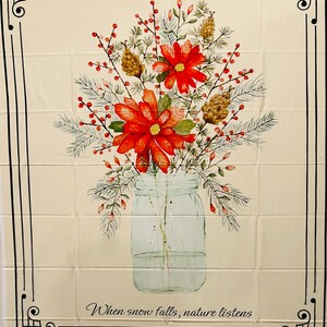 Op de afbeelding: Crèmekleurige stof met een bloemstuk in een weckpot. Het arrangement bevat rode bloemen, dennenappels en bessen. De tekst "When snow falls, nature listens" staat onderaan, omlijst door een zwarte rand.