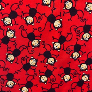 Può includere: Tessuto rosso con un motivo ripetuto di scimmie dei cartoni animati. Ogni scimmia è nera con un viso color beige, occhi bianchi e una bocca sorridente. Le scimmie sono in varie pose, con le braccia e le gambe tese.