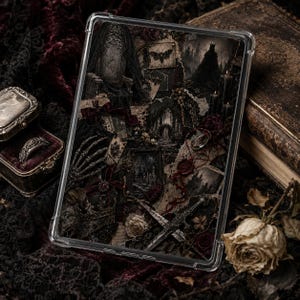 May include: A clear protective tablet case featuring a dark, gothic-inspired collage print. The design includes imagery of a skeletal hand, a dagger, a crown, a moth, wax seals, and dark floral elements in shades of black, deep red, and muted grey.