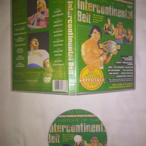 May include: A green DVD case for "The History of the Intercontinental Belt" featuring wrestlers. The case includes images of wrestlers and the words "Official Video" and "World Wrestling Federation". The DVD is also visible.