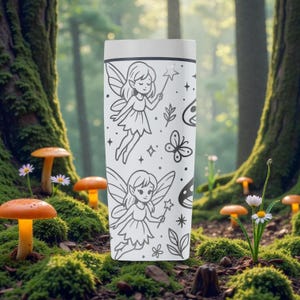 May include: White travel mug featuring a black line drawing of fairies, butterflies, stars, and floral elements. The mug has a white lid and a cylindrical shape. The design includes two fairies with wands, creating a whimsical theme.