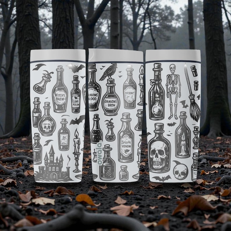 K&ouml;nnte beinhalten: Drei wei&szlig;e Becher mit einem gruseligen Halloween-Thema. Jeder Becher zeigt ein anderes Design von Zaubertr&auml;nken, Totenk&ouml;pfen, Flederm&auml;usen und einem Skelett. Die Becher stehen vor einem verschwommenen Waldboden.