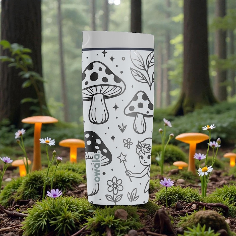 May include: White travel tumbler with a black and white mushroom and fairy design. The tumbler has a white lid and features the brand name "owala". The design includes mushrooms, stars, leaves, flowers, and a fairy with a wand.