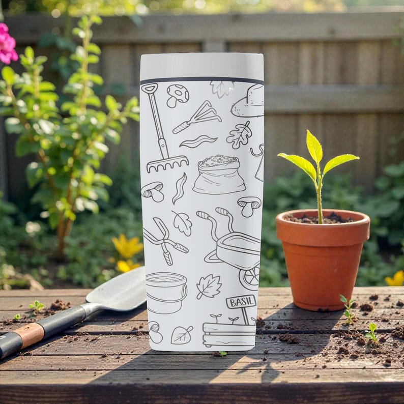 Puede incluir: Un vaso rectangular blanco con una ilustraci&oacute;n en blanco y negro con tem&aacute;tica de jard&iacute;n. El dise&ntilde;o incluye herramientas de jardiner&iacute;a, hojas y la palabra "BASIL" en un peque&ntilde;o letrero. Una peque&ntilde;a planta en maceta est&aacute; cerca.