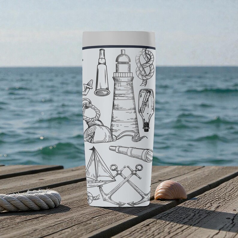 May include: A white travel mug featuring nautical-themed illustrations in black and white. Designs include a lighthouse, sailboat, anchor, rope knot, and a spyglass. The mug is cylindrical with a white lid, set against a wooden dock with the ocean in the background.