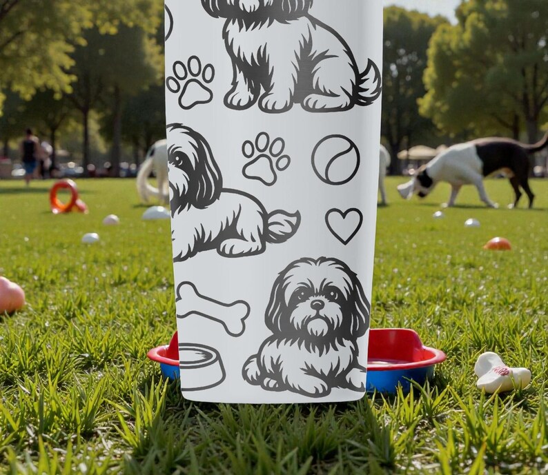 May include: White tumbler featuring black line art of Shih Tzu dogs, paw prints, a bone, a ball, and a heart. The tumbler is set in a park with dogs playing in the background. A red and blue dog bowl is in front of the tumbler.