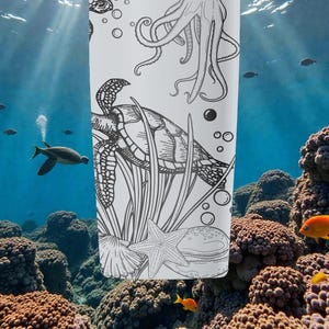 May include: A white tumbler with a black and white illustration of an octopus, sea turtle, starfish, and other marine life. The design is set against an underwater scene with coral and fish.