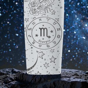 May include: A white tumbler featuring a black Scorpio zodiac design. The design includes the Scorpio symbol, zodiac signs, stars, and floral illustrations. The tumbler is set against a starry background.