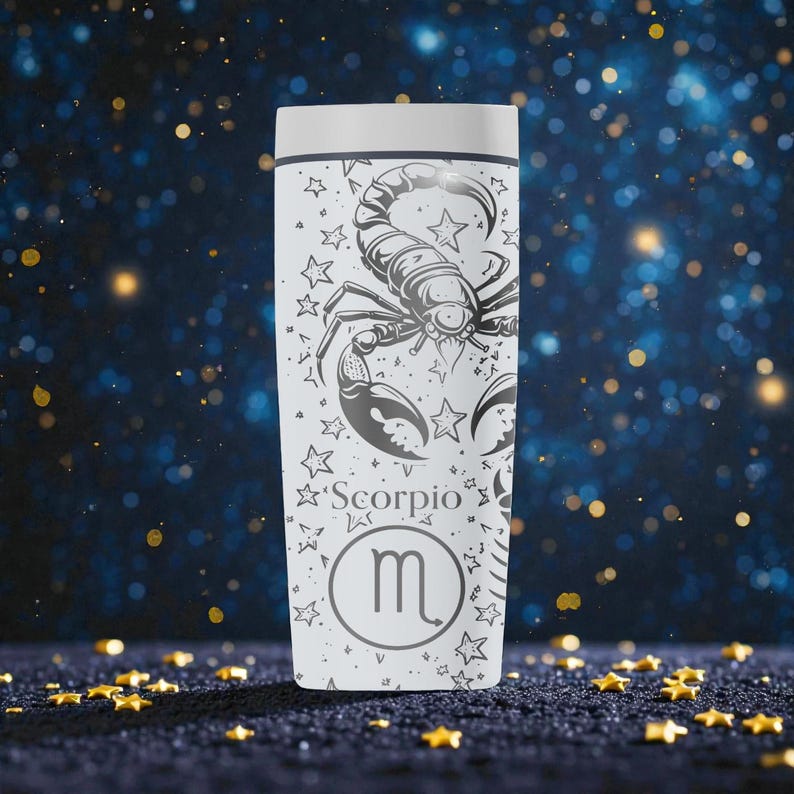 May include: White travel mug featuring a detailed black and gray illustration of a scorpion, surrounded by stars. The word "Scorpio" and the zodiac symbol are also displayed. The mug has a white lid and a cylindrical shape.