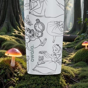 May include: A white Owala water bottle featuring black line art illustrations of characters and elements from Alice in Wonderland. The bottle is set against a forest backdrop with mushrooms.