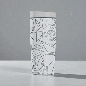 K&ouml;nnte beinhalten: Wei&szlig;er isolierter Reisebecher mit einem schwarzen Origami-Design mit V&ouml;geln, Blumen und einem Elefanten. Der Becher hat einen wei&szlig;en Deckel und der Markenname "owala" ist auf der Seite aufgedruckt. Zum Warm- oder Kalthalten von Getr&auml;nken.