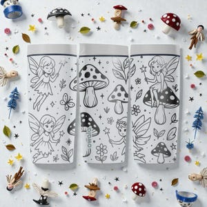 May include: Three white water bottles with black line art of fairies, mushrooms, and leaves. The bottles are surrounded by miniature mushroom figurines, stars, and leaves. The bottles have the word "owala" printed on them.