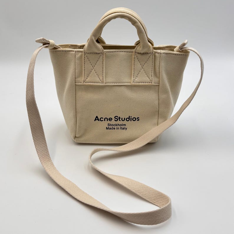 May include: A set of three ceramic mugs with a speckled, matte finish. The mugs are in shades of cream, light gray, and dark gray. Each mug has a simple, minimalist design and a rounded handle.