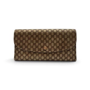 May include: A rectangular wallet in a tan and brown color scheme featuring a repeating interlocking G monogram pattern across the entire surface. The wallet has a curved flap closure secured by a single circular gold-toned metal snap button.