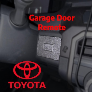 May include: A gray garage door remote button with a rectangular design is shown. The text "Garage Door Remote" is in red. The Toyota logo and the word "TOYOTA" are also in red.