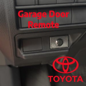 May include: A black dashboard component with the text "Garage Door Remote" in red. Below the text is a small rectangular button and the Toyota logo in red.