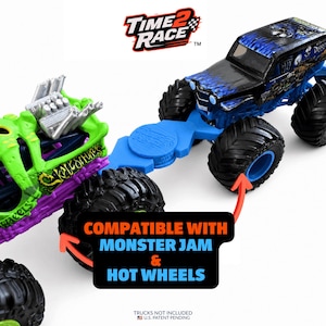 May include: A blue plastic connector piece labeled Time 2 Race, linking a green and purple monster truck toy to a black and blue monster truck toy. The image includes text stating COMPATIBLE WITH MONSTER JAM & HOT WHEELS and TRUCKS NOT INCLUDED.