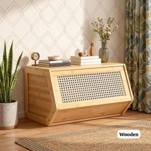 May include: A light-colored wooden cabinet with a slatted front panel and a flat top. The cabinet is rectangular with angled sides and is placed against a patterned wall. A small clock, books, and decorative items sit on top. The word "Wooden" is in the image.