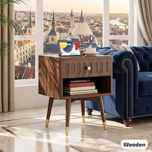May include: A wooden nightstand with a drawer and open shelf. The nightstand has a dark brown finish with gold-tipped legs. A tablet, lamp, and books are on top. The word "Wooden" is in the bottom right corner.