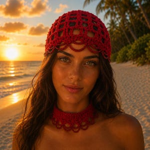 May include: A red crocheted head covering and matching choker necklace. The head covering has a net-like design with a scalloped edge. The choker necklace also has a scalloped edge. The items are made of a red yarn and are worn on a beach at sunset.
