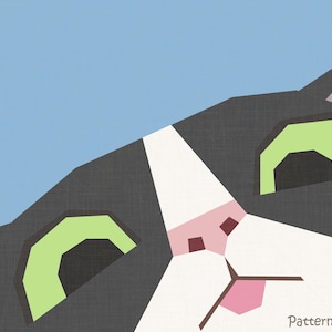 May include: A graphic illustration of a cat face with dark gray and white fur, large light green eyes, and a pink nose against a light blue background. The text "Patterns by LittleTinyPiranha" is printed in the bottom right corner of the image.