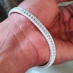 May include: A handmade wooden sign with the text "Welcome to our home" in a handwritten style. The sign is painted white with a distressed finish and a dark brown border. A small, decorative heart is attached to the bottom.