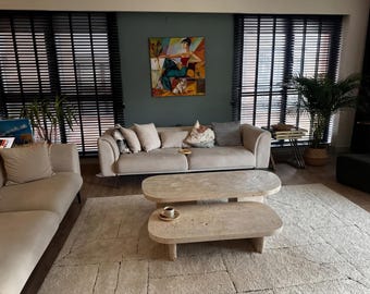 Mesa de centro ovalada escultural de travertino / Sala de estar moderna y orgánica