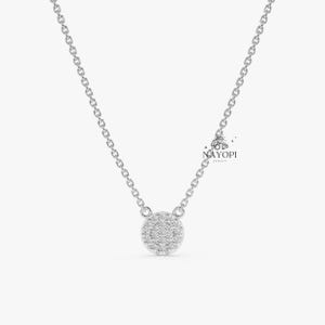 Round diamond cluster pendant on thin yellow gold chain necklace.