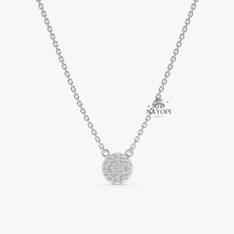 Round diamond cluster pendant on thin yellow gold chain necklace.