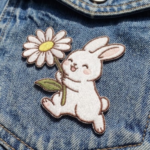 May include: A set of three ceramic nesting bowls in graduating sizes. The bowls are white with a speckled, textured finish and feature a slightly flared rim. The largest bowl measures approximately 8 inches in diameter.