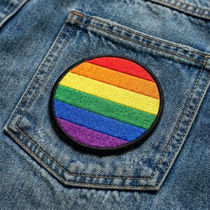 May include: A white ceramic mug with a black handle and the text "But First, Coffee" in a bold, black font. The mug is filled with a dark liquid, likely coffee, and sits on a light-colored surface.