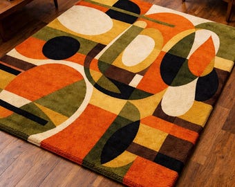 May include: A rectangular area rug featuring a bold geometric pattern with overlapping shapes in shades of orange, olive green, mustard yellow, cream, and black. The design consists of large circles, semi-circles, and rectangular blocks.