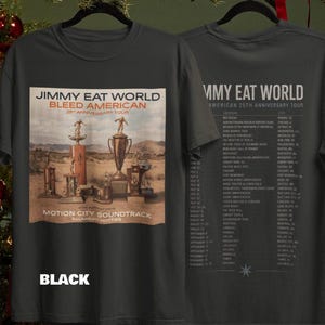 May include: A black short-sleeve t-shirt featuring a graphic on the front and back. The front displays a desert scene with multiple trophies and the text "JIMMY EAT WORLD BLEED AMERICAN 25TH ANNIVERSARY TOUR". The back lists tour dates and locations.