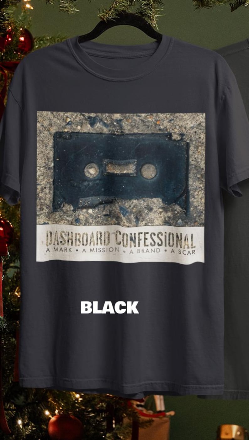 May include: Black t-shirt featuring a graphic of a cassette tape on a concrete surface. The text "DASHBOARD CONFESSIONAL" is printed below the graphic, with the words "A MARK &bull; A MISSION &bull; A BRAND &bull; A SCAR". The word "BLACK" is printed at the bottom.