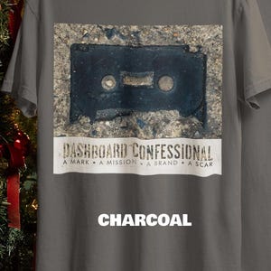 May include: Charcoal gray t-shirt featuring a distressed image of a cassette tape. Below the image is the text "DASHBOARD CONFESSIONAL" and the words "A MARK &bull; A MISSION &bull; A BRAND &bull; A SCAR". The word "CHARCOAL" is printed at the bottom.