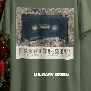 May include: Military green t-shirt featuring a distressed image of a black cassette tape. Below the image is the text "DASHBOARD CONFESSIONAL" and the words "A MARK &bull; A MISSION &bull; A BRAND &bull; A SCAR". The text "MILITARY GREEN" is below.