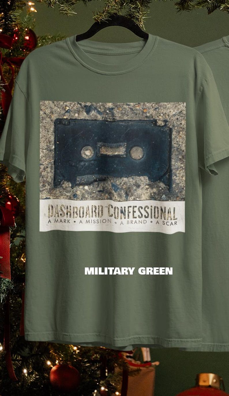 May include: Military green t-shirt featuring a distressed image of a black cassette tape. Below the image is the text "DASHBOARD CONFESSIONAL" and the words "A MARK &bull; A MISSION &bull; A BRAND &bull; A SCAR". The text "MILITARY GREEN" is below.