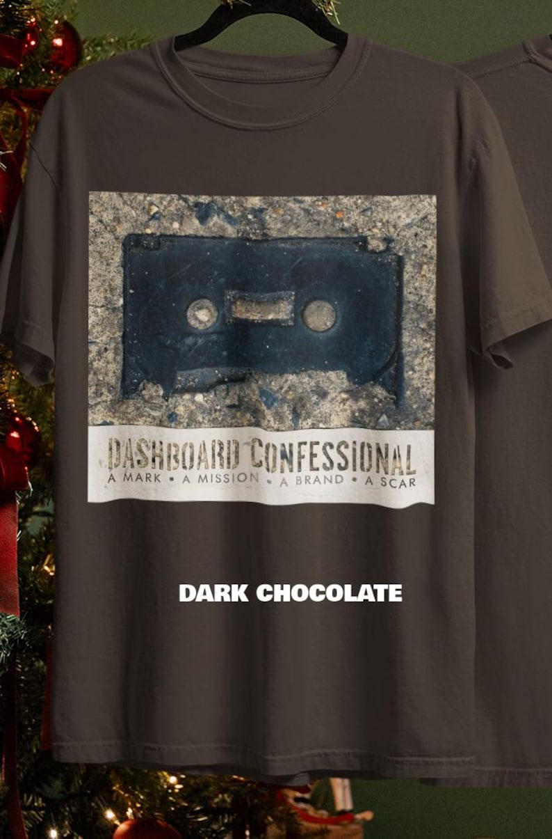 May include: Dark chocolate-colored t-shirt featuring a distressed image of a cassette tape. Below the image is the text "DASHBOARD CONFESSIONAL" and the words "A MARK &bull; A MISSION &bull; A BRAND &bull; A SCAR". The text "DARK CHOCOLATE" is printed at the bottom.