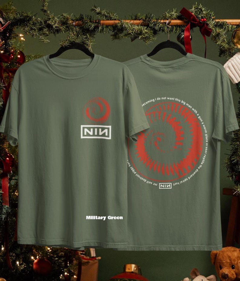 May include: Military green t-shirts with a red spiral design and the text "NIN". One shirt displays the NIN logo and the text "Military Green". The other shirt has a spiral design with text around it.