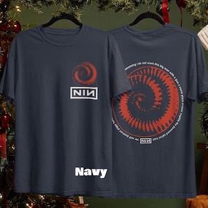 May include: Navy blue t-shirts with a red spiral design and the text "NIN" in a white rectangle. The back of the shirt features the spiral design and text. The word "Navy" is printed at the bottom of the shirt.