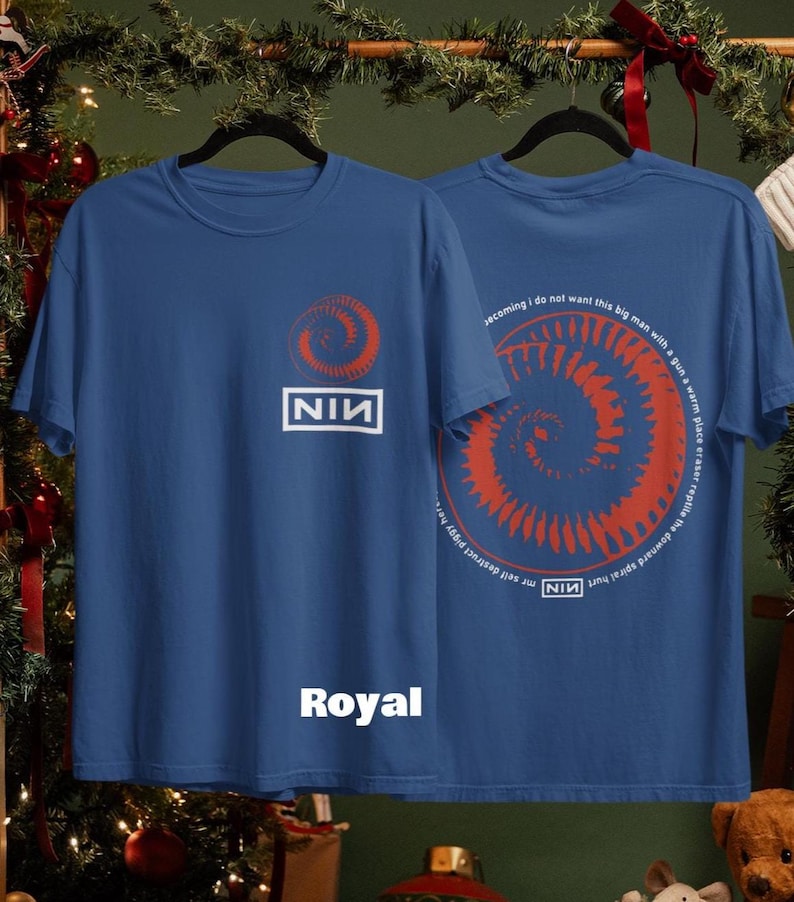 May include: Royal blue t-shirts with a red spiral design and the text "NIN". One shirt displays the logo, the other has a spiral and text. The word "Royal" is printed on the front of one shirt.