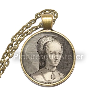 May include: A gold chain necklace with a round pendant featuring a black and white portrait of a woman wearing a white head covering and a pearl necklace. The pendant has a gold rim.